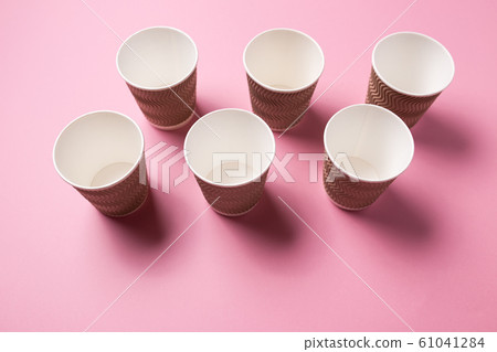 Paper cup for hot coffee or tea on a pink isolated background. 61041284