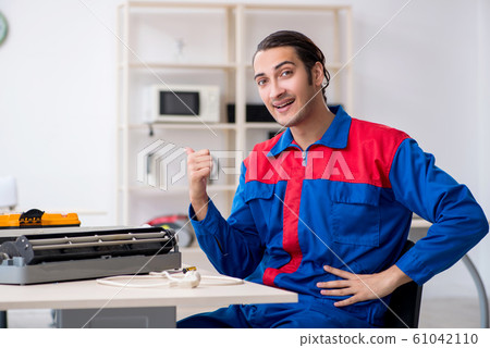 Young repairman repairing air-conditioner at warranty center 61042110