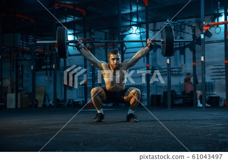 Caucasian man practicing in weightlifting in gym 61043497
