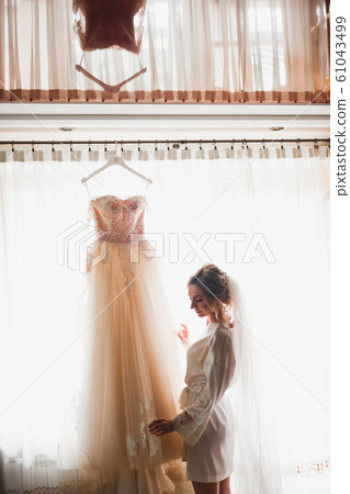 Luxury bride in white dress posing while preparing for the wedding ceremony 61043499