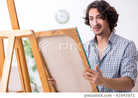 Young handsome man enjoying painting at home 61043971