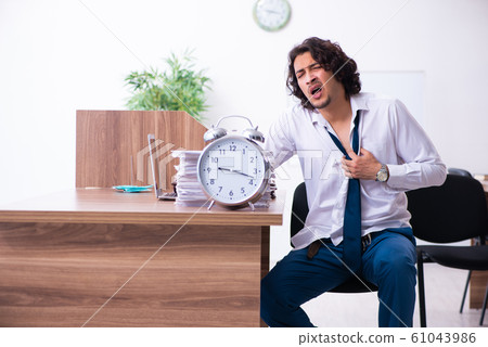 Young male employee unhappy with excessive work Young male employee unhappy with excessive work 61043986