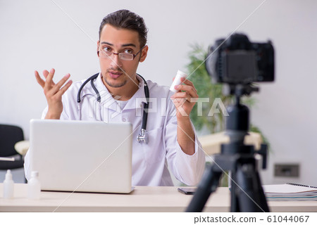 Young male doctor recording video for his blog 61044067