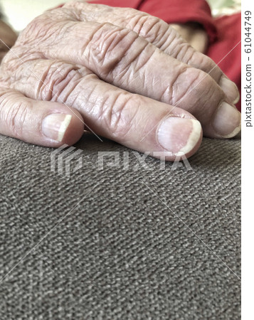 closeup wrinkled hand of a senior woman closeup wrinkled hand of a senior woman 61044749