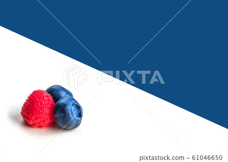 Blueberries and raspberry on white and blue background. 61046650