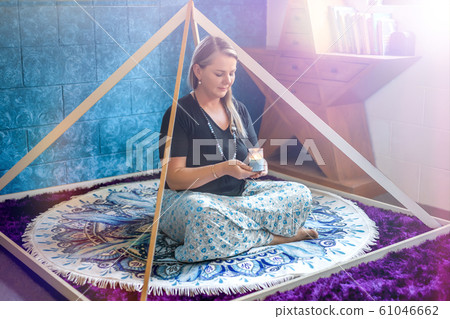 Woman meditating with a candle Woman meditating with a candle 61046662