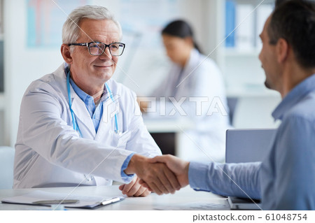 Doctor and patient shaking hands Doctor and patient shaking hands 61048754