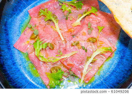 tuna carpaccio with capers and lettuce 61049206