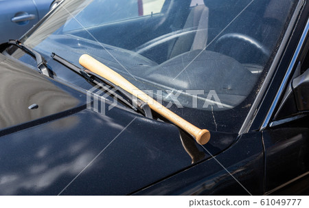 Wooden baseball bat lies on the car Wooden baseball bat lies on the car 61049777