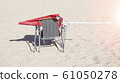 red sun umbrella on a chair on the beach 61050278