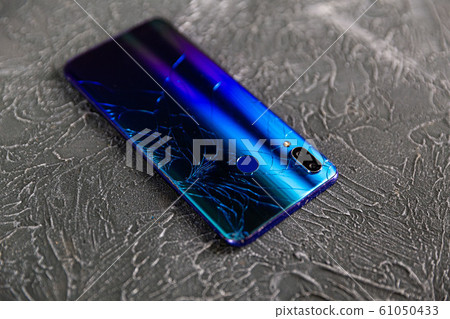 Broken glass screen smartphone in hand of upset girl, white background 61050433