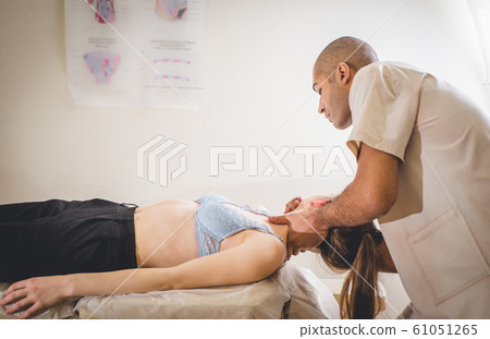 Chiropractor doing adjustment on female patient 61051265
