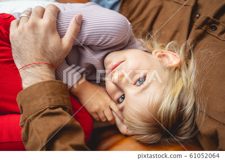 Adorable little girl cuddling with dad at home Adorable little girl cuddling with dad at home 61052064