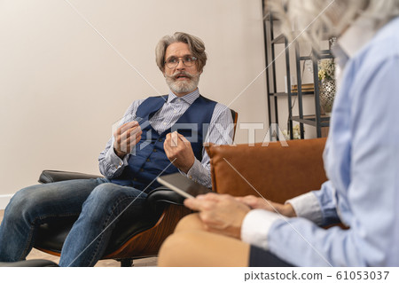 Calm man talking to a female psychotherapist 61053037
