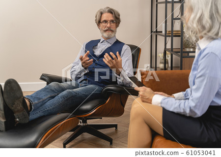 Worried middle-aged man talking to his psychotherapist 61053041
