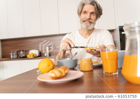 Man spreading peanut butter with a knife Man spreading peanut butter with a knife 61053750