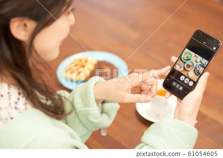 A woman looking at a picture of a dish A woman looking at a picture of a dish 61054605