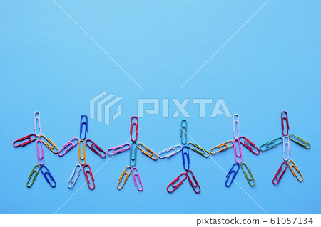 Person holding hands shaped by colorful zem clips under blue construction paper 61057134