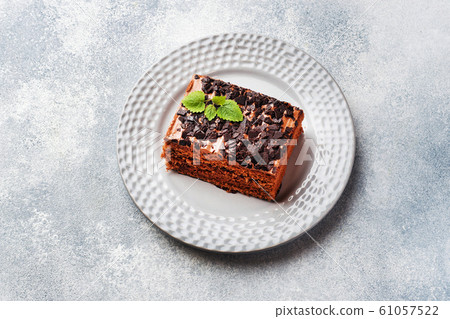A piece of truffle cake with chocolate on a gray A piece of truffle cake with chocolate on a gray 61057522