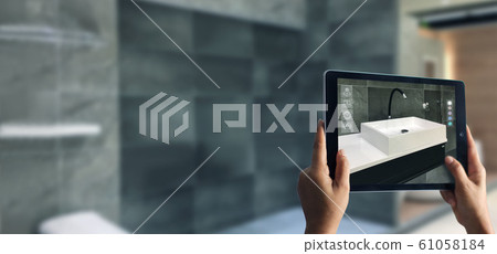 Augmented Reality bathroom planning. Sanitary ware. Hand holding digital tablet in real home background, AR application. A new way to experience products. Augmented Reality bathroom planning. Sanitary ware. Hand holding digital tablet in real home background, AR application. A new way to experience products. 61058184