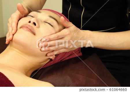 一個女人接受面部美容 一個女人接受面部美容 61064660