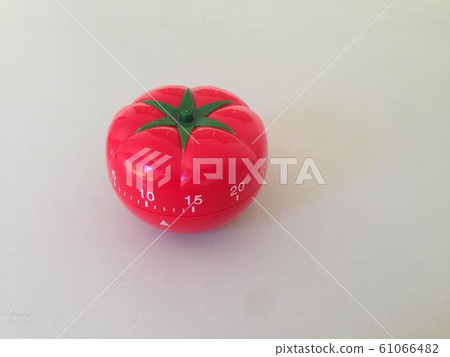 Pomodoro Timer red with green details. Tomato on the table. Vibrant, multi-angle colors. Pomodoro Timer red with green details. Tomato on the table. Vibrant, multi-angle colors. 61066482