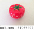 Pomodoro Timer red with green details. Tomato on the table. Vibrant, multi-angle colors. 61066494