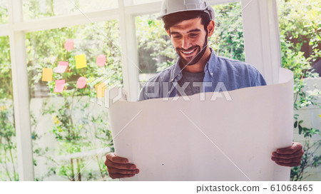 Architect looking at blue print project with a Architect looking at blue print project with a 61068465