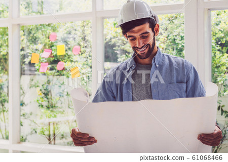 Architect looking at blue print project with a 61068466