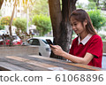 Woman using mobile phone on desk, smile and happy on holiday, technology concept 61068896