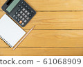 Empty notepad and calculator and pencil on wooden desk, copy space, top view background 61068909