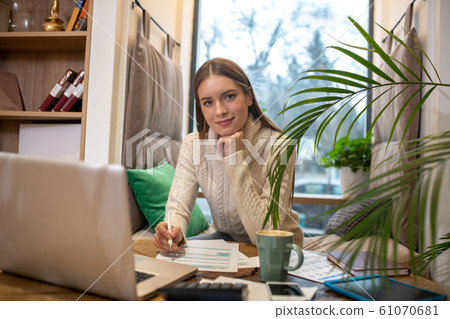 Confident young woman doing accounting for her business Confident young woman doing accounting for her business 61070681