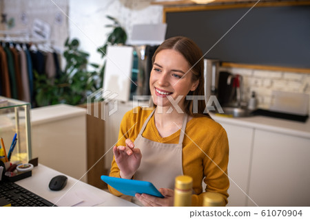 Attentive cafe employee using the tablet for taking order Attentive cafe employee using the tablet for taking order 61070904