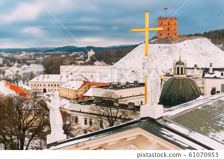 Vilnius Lithuania. Close Pediment Of Cathedral Basilica Of St. Stanislaus, St. Vladislav With Statues Of St. Elena And St. Stanislaus ,Tower Of Gediminas Or Gedimino In Winter Day Vilnius Lithuania. Close Pediment Of Cathedral Basilica Of St. Stanislaus, St. Vladislav With Statues Of St. Elena And St. Stanislaus ,Tower Of Gediminas Or Gedimino In Winter Day 61070953