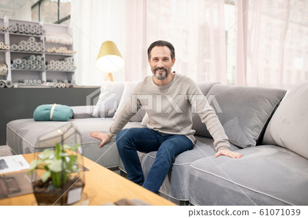 Man in light sweater and jeans feeling good 61071039