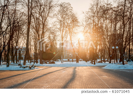 Gomel, Belarus. Sun at sunset shining above Rumyantsev-paskevich Palace In Snowy City Park. Winter Sunny Day Gomel, Belarus. Sun at sunset shining above Rumyantsev-paskevich Palace In Snowy City Park. Winter Sunny Day 61071045