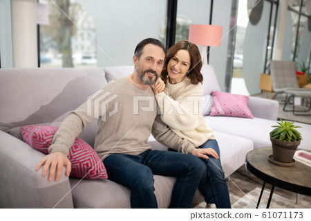 Couple sitting on the cosy beautiful sofa and smiling 61071173
