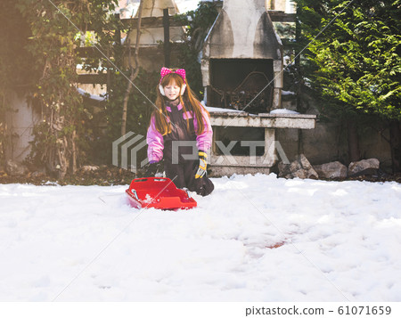 Little redhead girl playing in winter with snow Little redhead girl playing in winter with snow 61071659