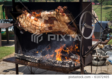 Piglet roasted on a spit Piglet roasted on a spit 61072405