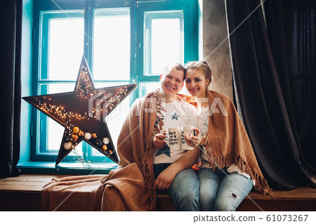 Romantic couple sitting on windows hill with 61073267