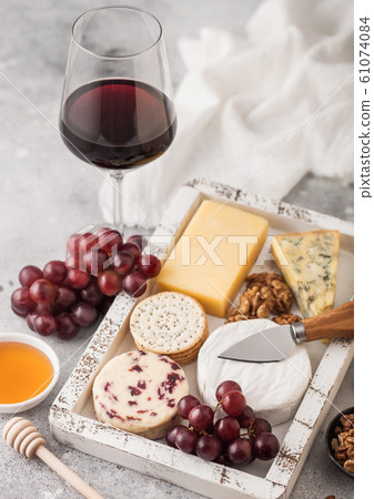 Glass of red wine with selection of various cheese 61074084