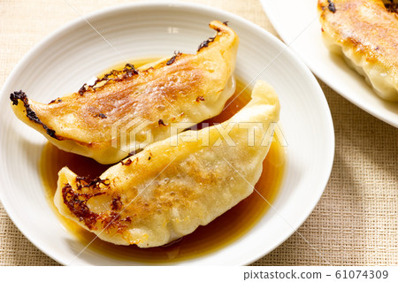 煎餃子放入一小盤餃子醬。 煎餃子放入一小盤餃子醬。 61074309