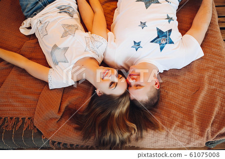 Above view of young couple laying together in bed Above view of young couple laying together in bed 61075008