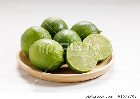 Fresh green limes and half on white wooden 61078702
