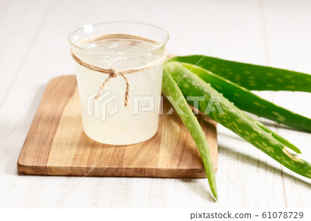 aloe vera juice in a glass on wooden paddle board 61078729