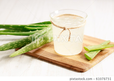 aloe vera juice in a glass on wooden paddle board 61078731