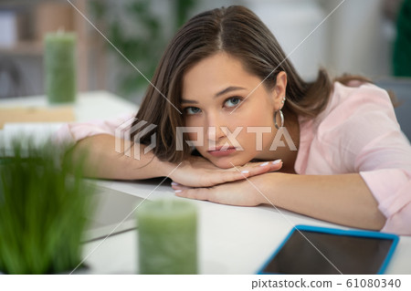 Sad cheerless woman being tired from her work Sad cheerless woman being tired from her work 61080340