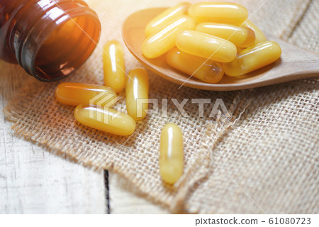 Royal jelly capsules in wooden spoon and sack 61080723