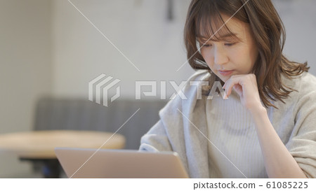 Woman operating a laptop in a cafe 61085225