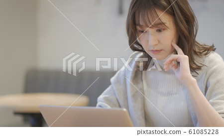 Woman operating a laptop in a cafe 61085228